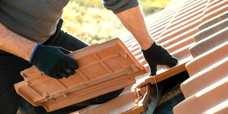 roofer fitting ceramic roof tiles 